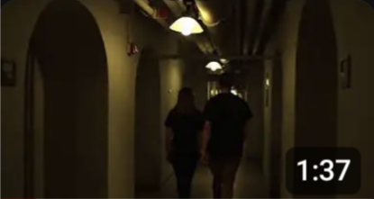 A YouTube thumbnail of two shadowed people walking down a dark hallway.